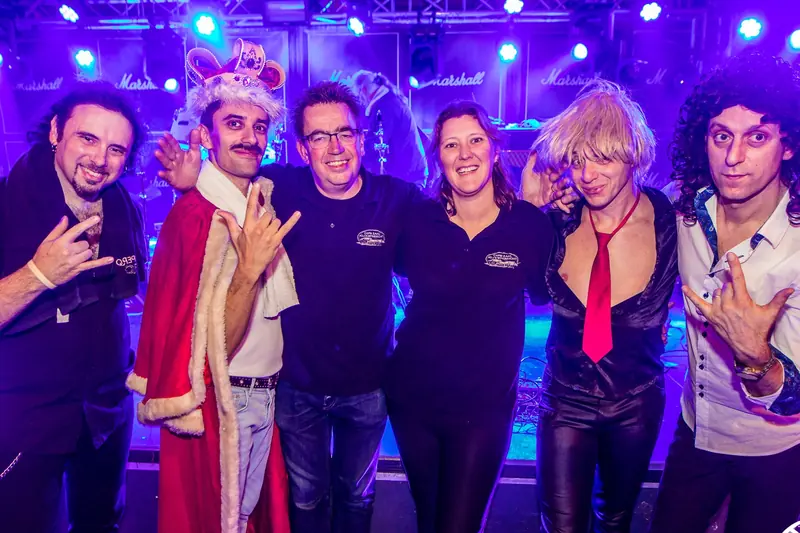 Een band in verkleedkleding poseert met het personeel