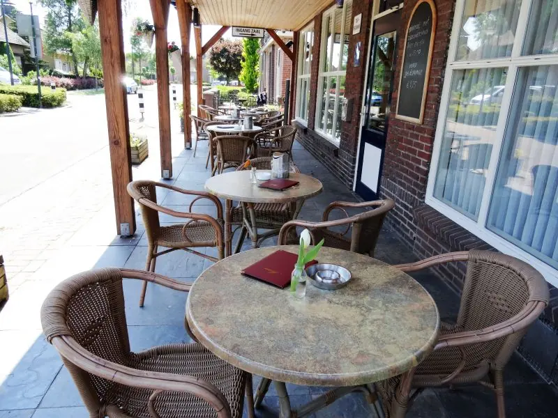 Het terras aan de straat met rieten stoelen