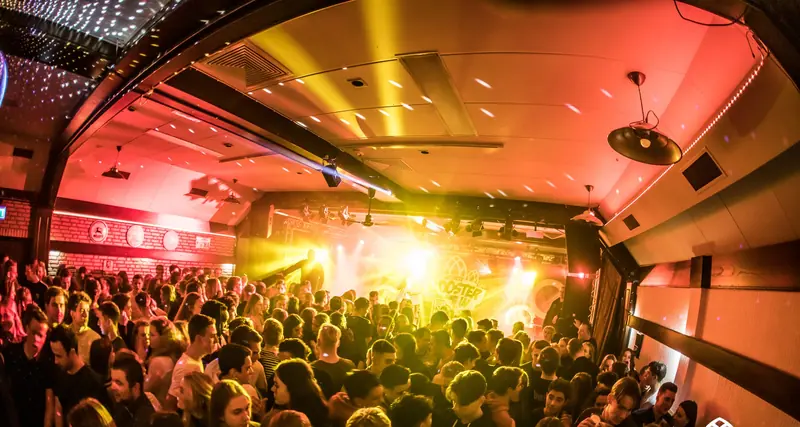 De zaal tijdens een feestavond, vol mensen voor het podium