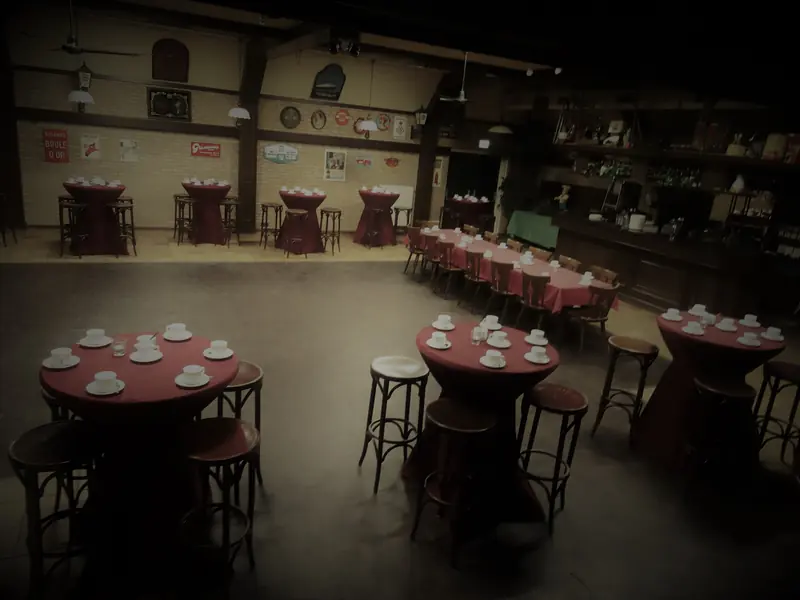 De zaal met rode tafelkleden en statafels