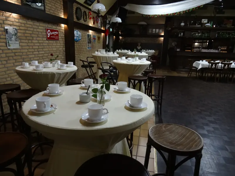 De zaal met witte tafelkleden en statafels